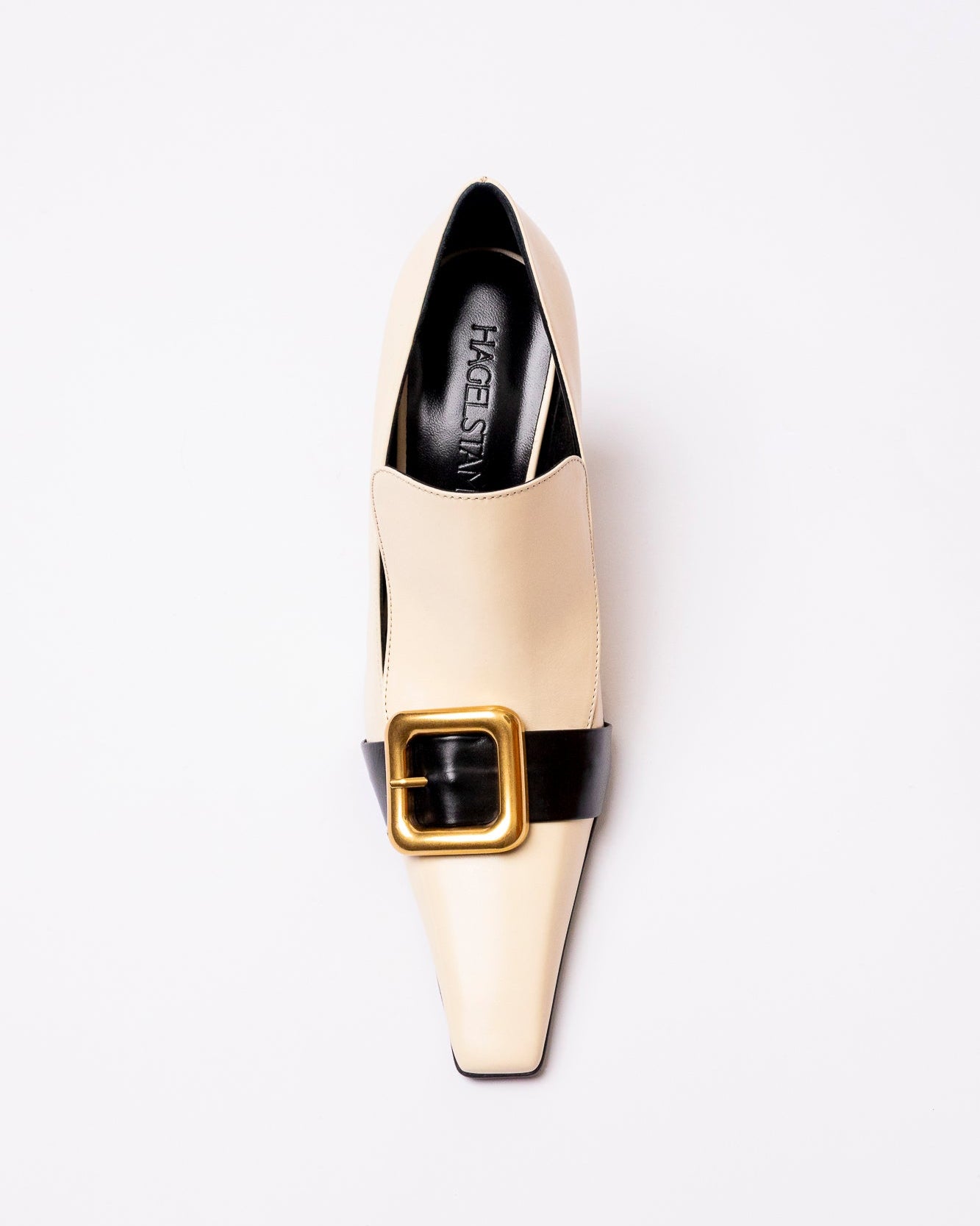 White shoe with black buckle on a white background