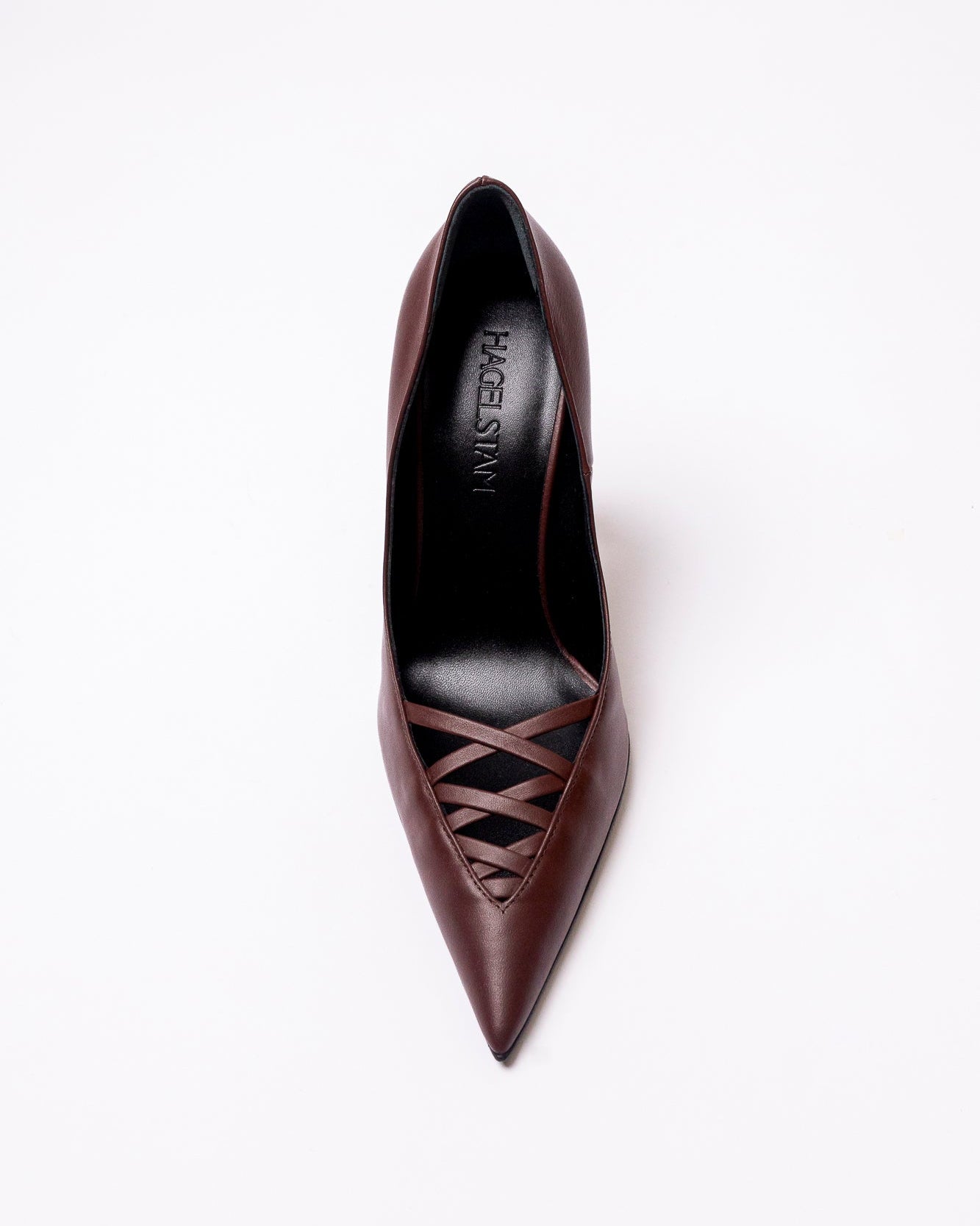 Brown high-heeled shoe with decorative cutout design on a white background
