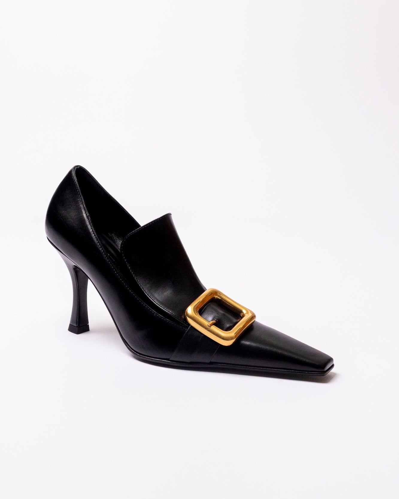 Black high-heeled shoe with a gold buckle on a white background