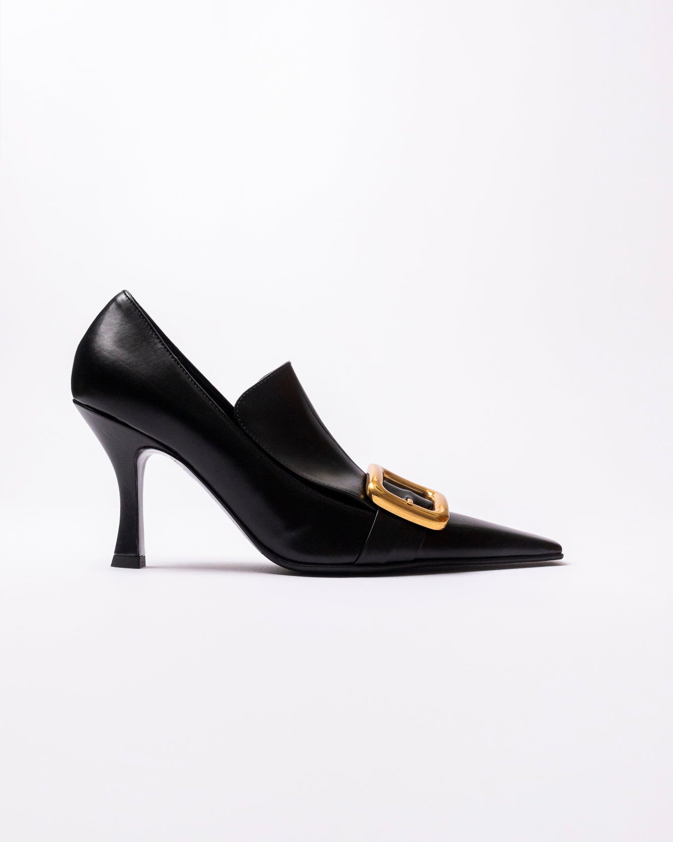 Black high-heeled shoe with a gold buckle on a white background