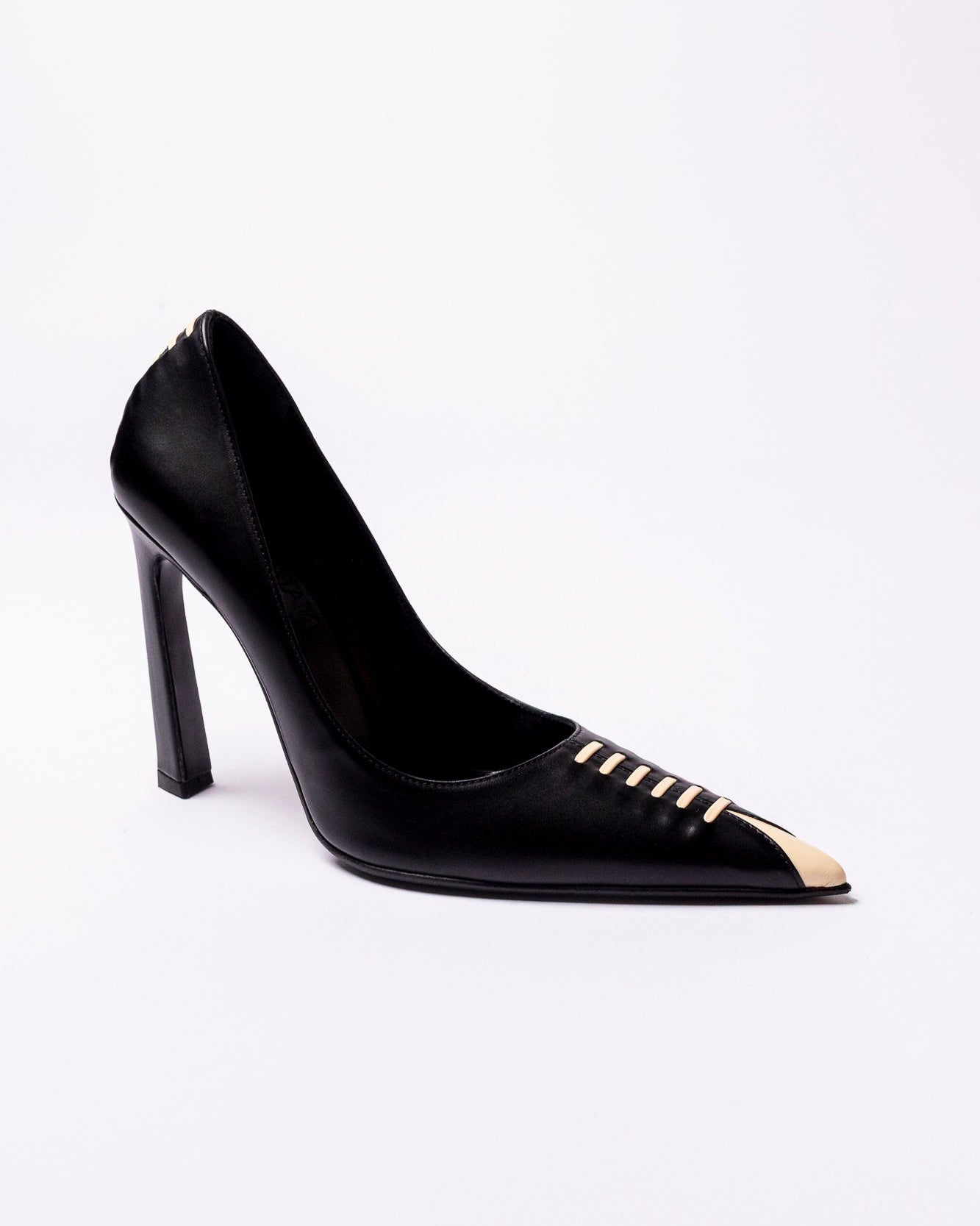 Black high-heeled shoe with gold accents on a white background
